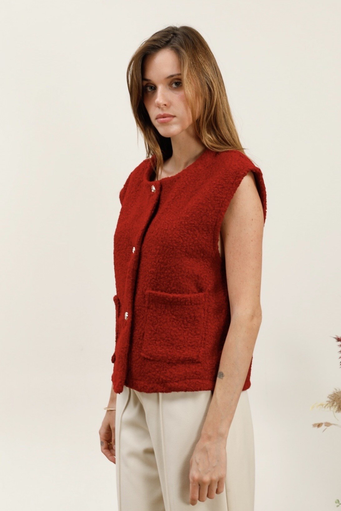 Gold -eyed sleeveless vest with golden button